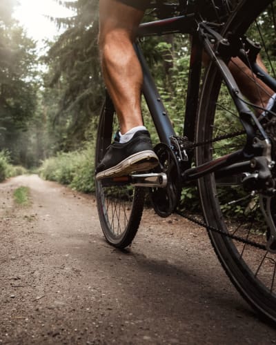 Resident riding his mountain bike through a forested area near Vantage Park Apartments in Seattle, Washington