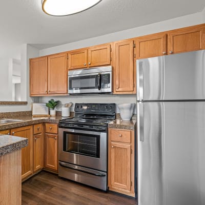 Modern kitchen with stainless-steel appliances in a model home at Timbers at Tualatin in Tualatin, Oregon