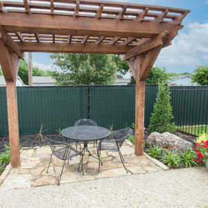 Poolside patio table and chairs under a pergola at Vista Verde in Mesquite, Texas