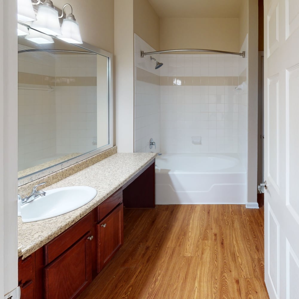 large bathtub and large vanity mirror in a townhome's bathroom at Oaks Estates of Coppell in Coppell, Texas