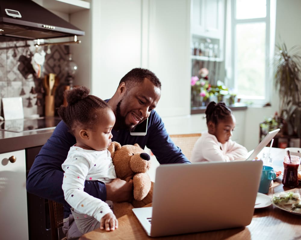 Resident working from home with his children at Clocktower Mill and Velvet Mill Apartments in Manchester, Connecticut