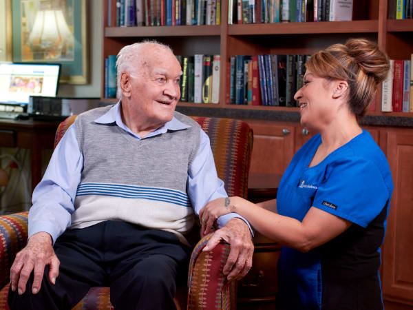 Resident enjoying a conversation with a caretaker at Las Palomas Senior Living in Mesa, Arizona
