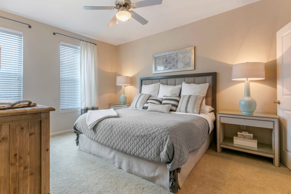 Spacious model bedroom with plush carpeting and a ceiling fan at The Village at Apison Pike in Ooltewah, Tennessee