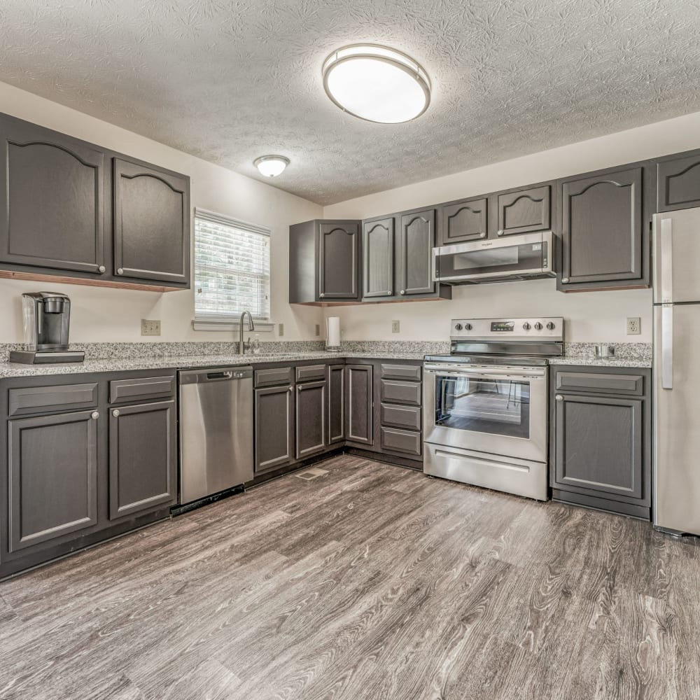 Kitchen with stainless-steel appliances and wood-style flooring at Walton Crossings, Jeannette, Pennsylvania