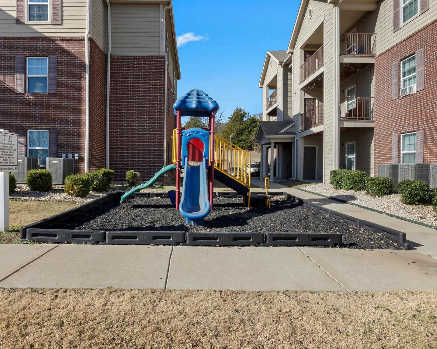 Colorful playground with slide beside modern apartment building at Wickham Gardens in Sapulpa, Oklahoma 