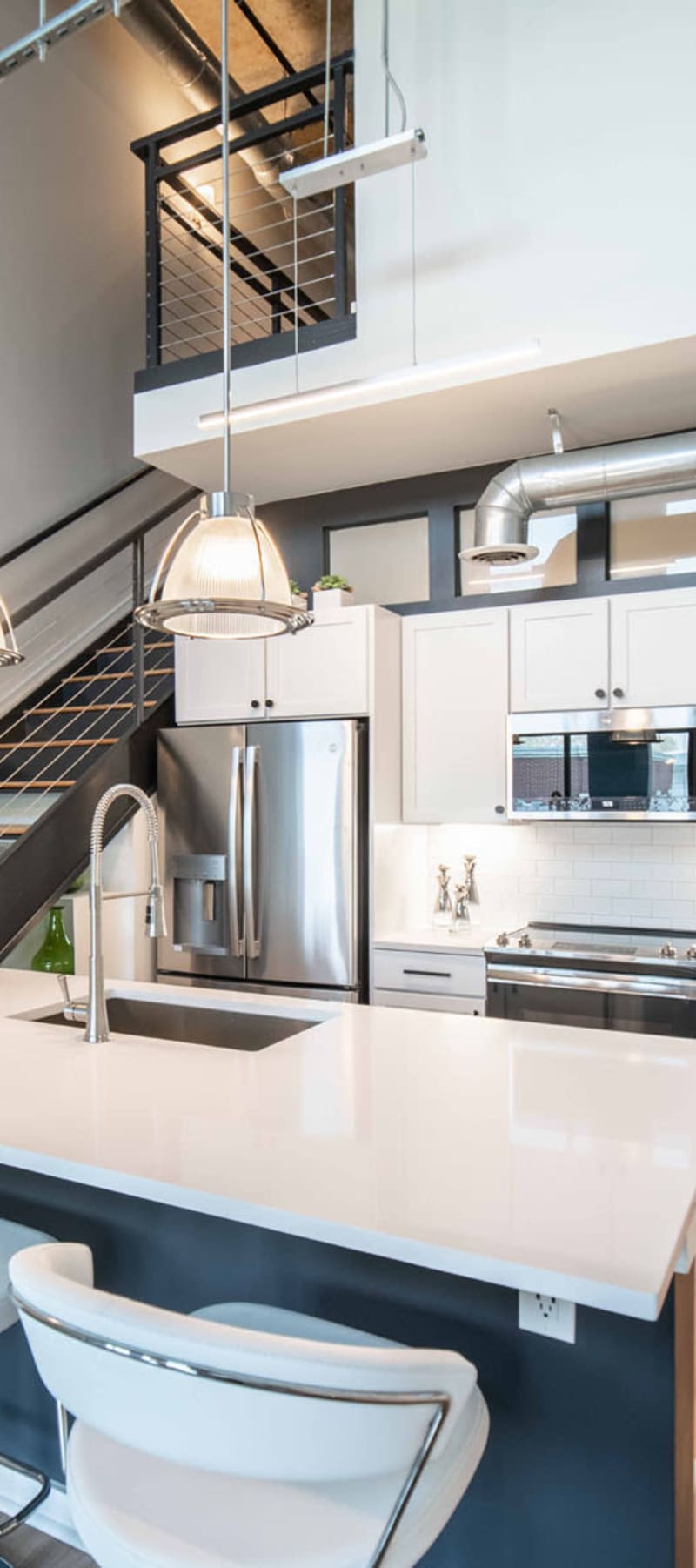 Open-concept kitchen with quartz countertops and stainless-steel appliances in a model loft at 17th Street Lofts in Atlanta, Georgia