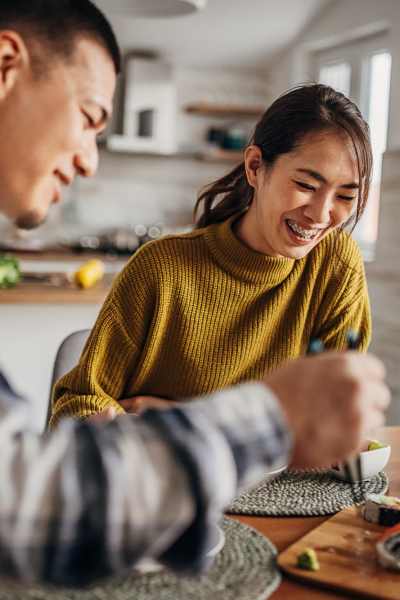 Bright kitchen with couple enjoying meal at table at Valley Brook Townhomes in Rochester, New York