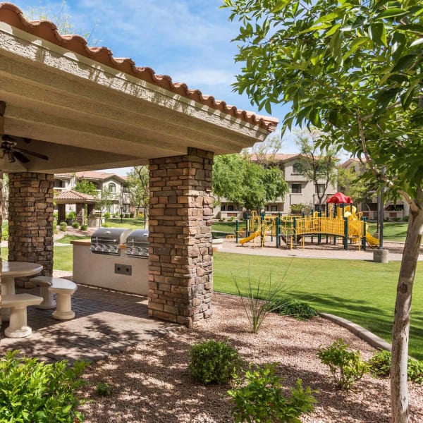 Covered Ramada with gas grills and overlooking playground at San Hacienda in Chandler, Arizona