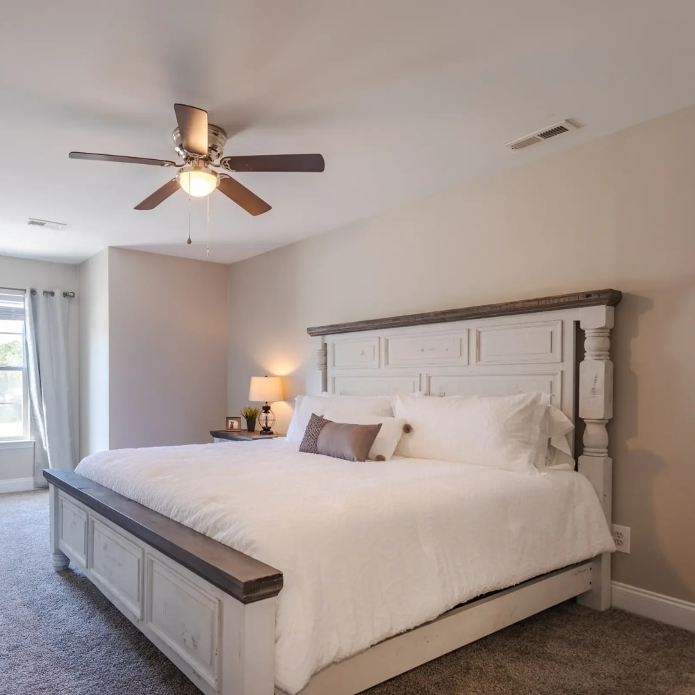 Bedroom with comfortable bed and ceiling fan at Avalon I Apartments in North Charleston, South Carolina