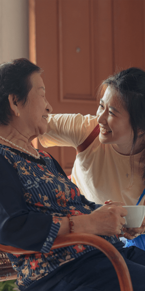 Caretaker talking to a seated resident at The Crossroads at Bon Air in Richmond, Virginia