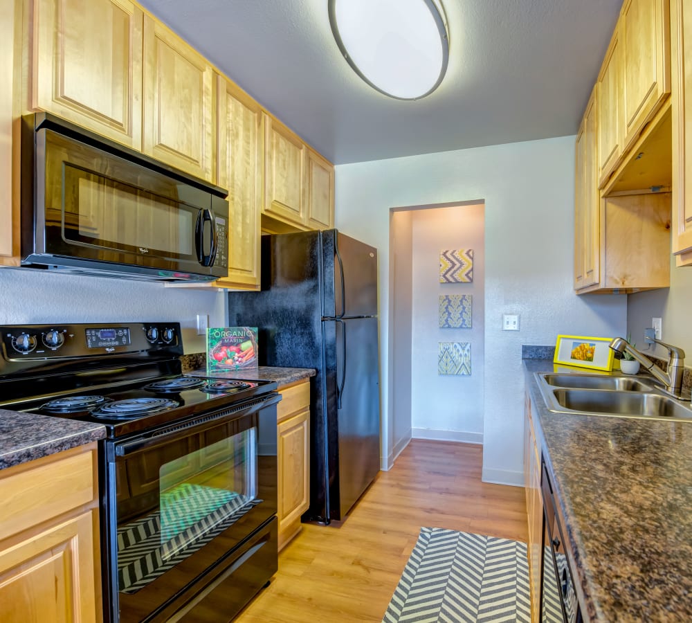 Granite countertops and black appliances in a model home's kitchen at Sofi Laguna Hills in Laguna Hills, California