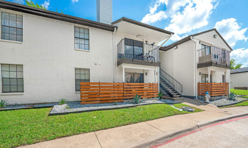 Outside an apartment building with private balconies and patios at The Haylie in Garland, Texas