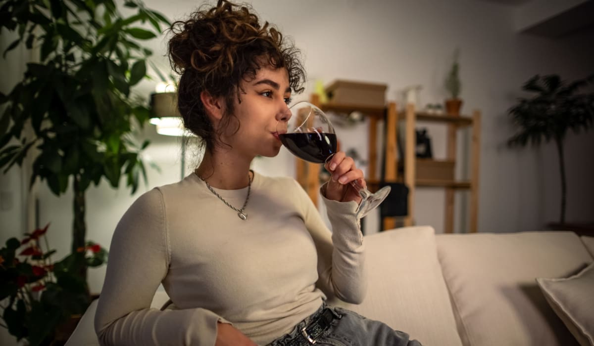 Resident relaxing with a glass of wine in her home at Village at Santa Teresa in Gilroy, California