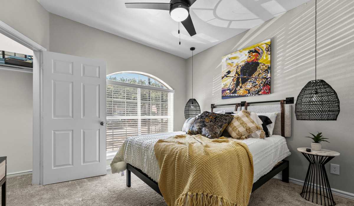 Spacious bedroom with comfortable bed and a ceiling fan at Station 3700 in Euless, Texas