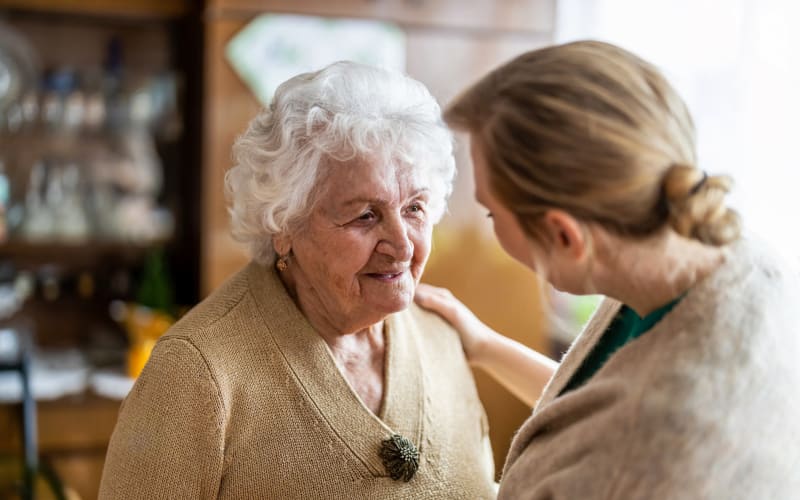 Staff member talking with a resident at Grand Villa of Palm Coast in Palm Coast, Florida