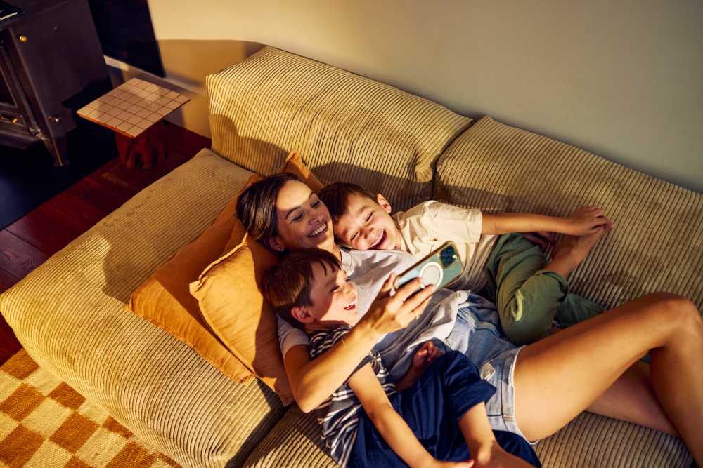Resident playing with her kids in the living room at Mosaic in Shelton, Connecticut