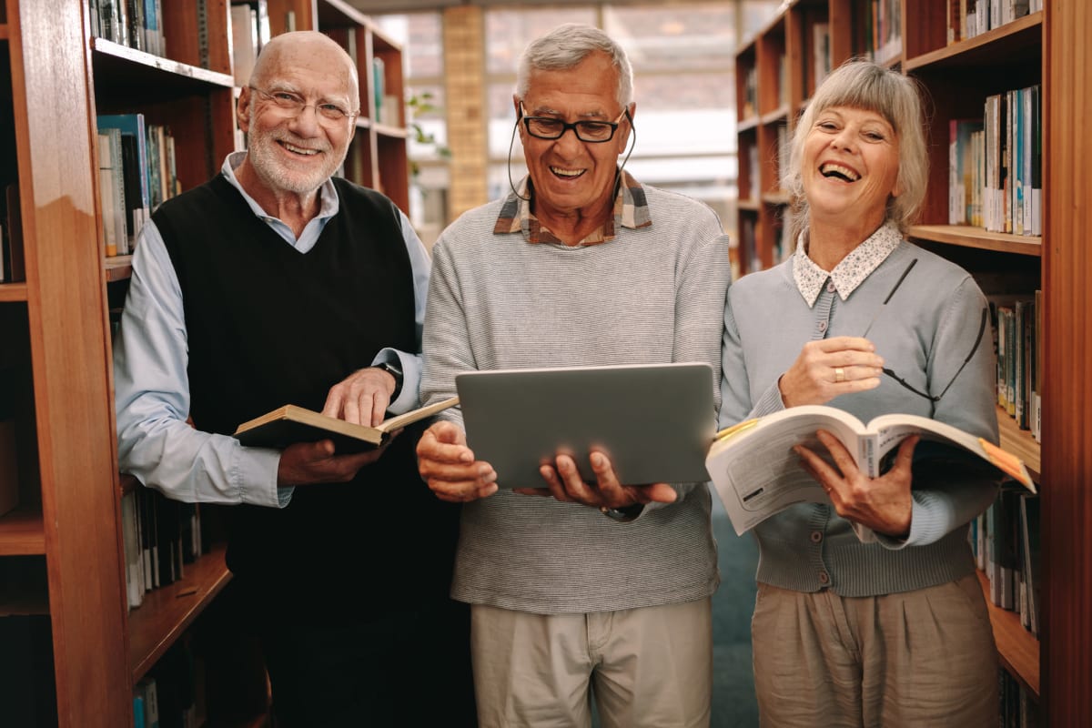 A group of residents in the library near Claiborne Senior Living.