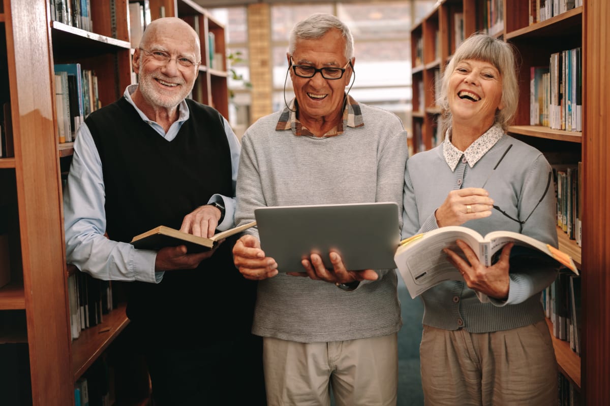 A group of residents in the library near Claiborne Senior Living. 