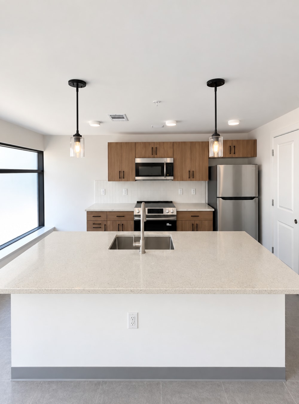 Bright kitchen featuring a large island, wood cabinetry, and natural light at Altitude on Main in Richmond, Virginia