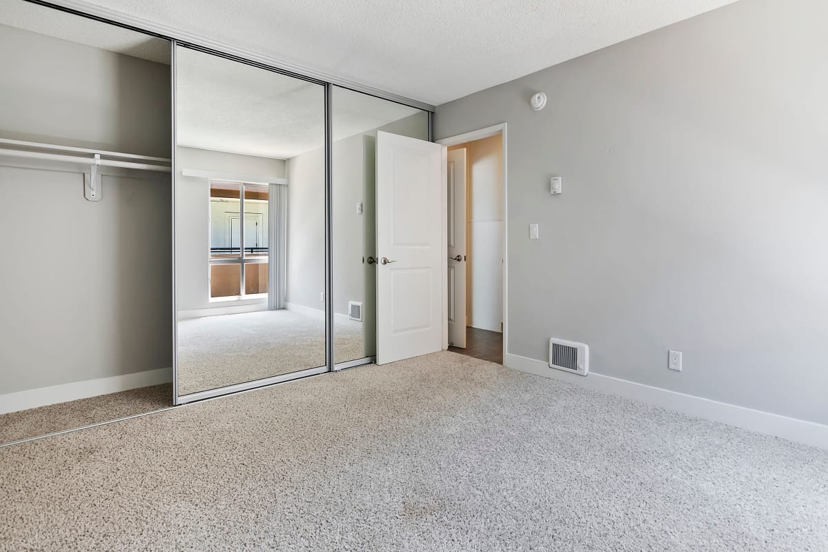 Bedroom with mirrored closet doors at Westside Terrace, Los Angeles, California