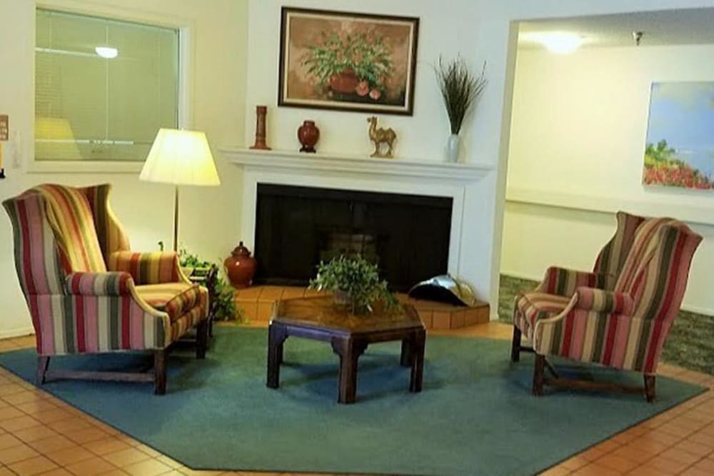 Fireplace with comfy chairs to sit in and enjoy the warmth at Leisure Manor Senior Living in Sacramento, California
