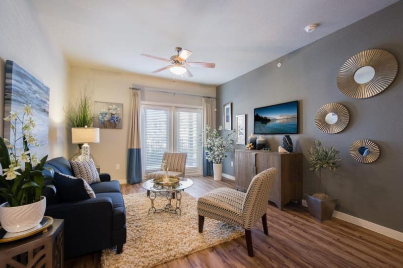 Large living room with area rug and ceiling fan at Verandas at Alamo Ranch in San Antonio, Texas