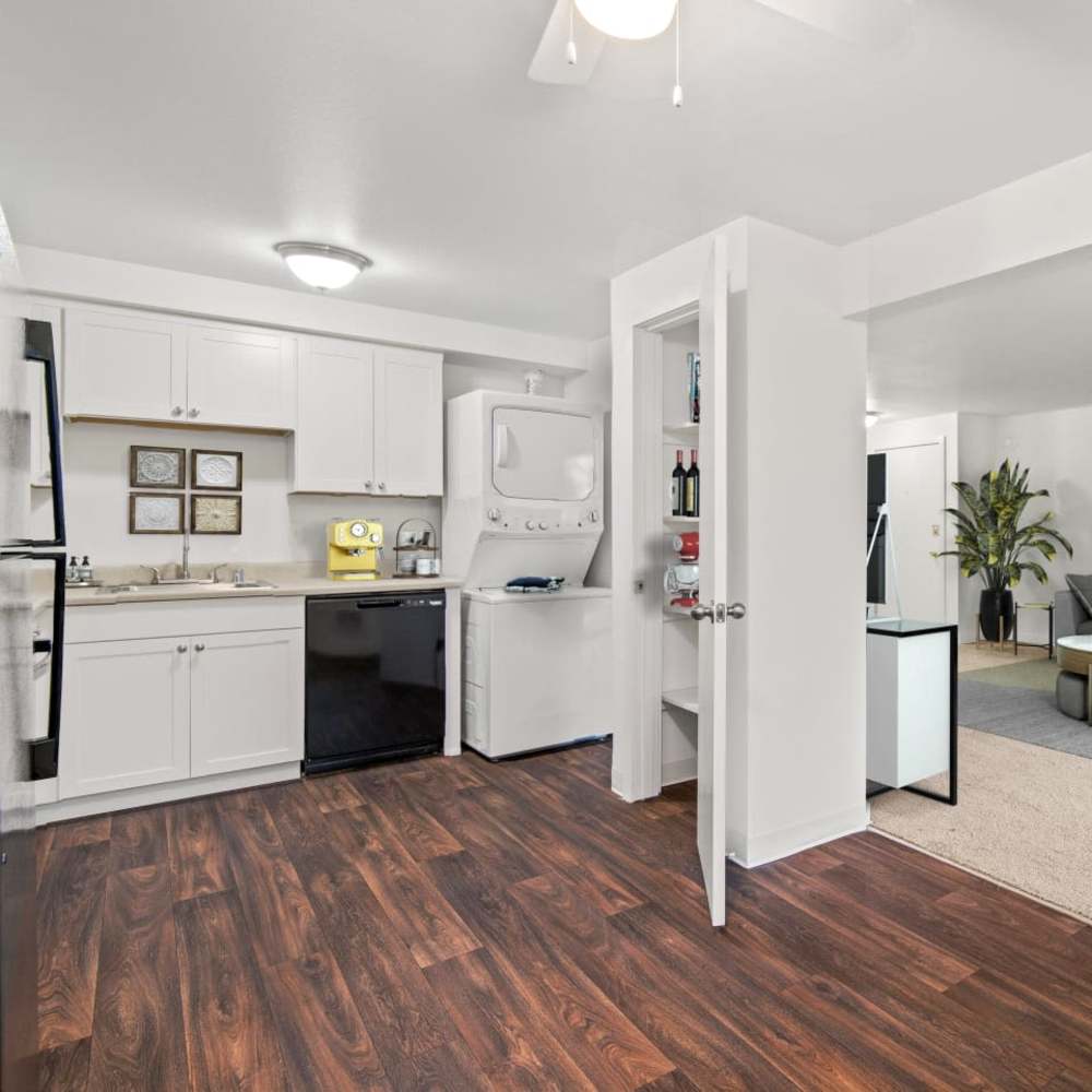 Kitchen with wood-style flooring, white cabinetry, and a dishwasher at Bluffs at Evergreen in Everett, Washington