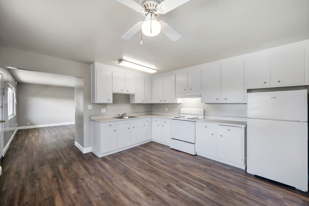 Kitchen with wood-style flooring and stainless-steel appliances at Garden Court Apartments in Alameda, California