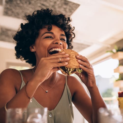 Resident eating a burger with friends at a local restaurant near 1869 West in Pittsburgh, Pennsylvania