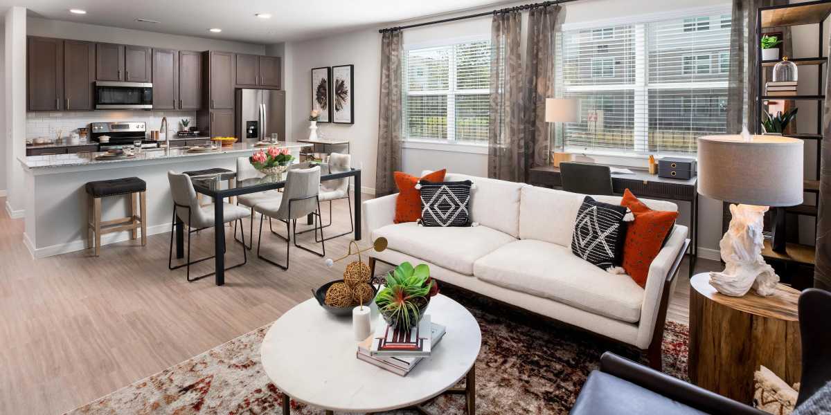 living room and kitchen with wood-style flooring and modern furnishings at August Friendswood in Friendswood, Texas