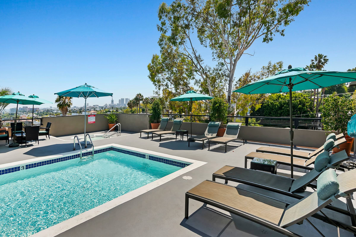 Pool with lounge chairs and umbrellas at Ascent, West Hollywood, California