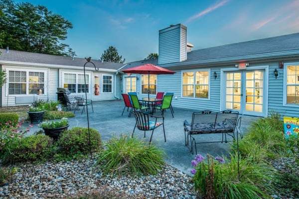 Outdoor patio with area with patio table and umbrella at Randall Residence of Fremont in Fremont, Ohio