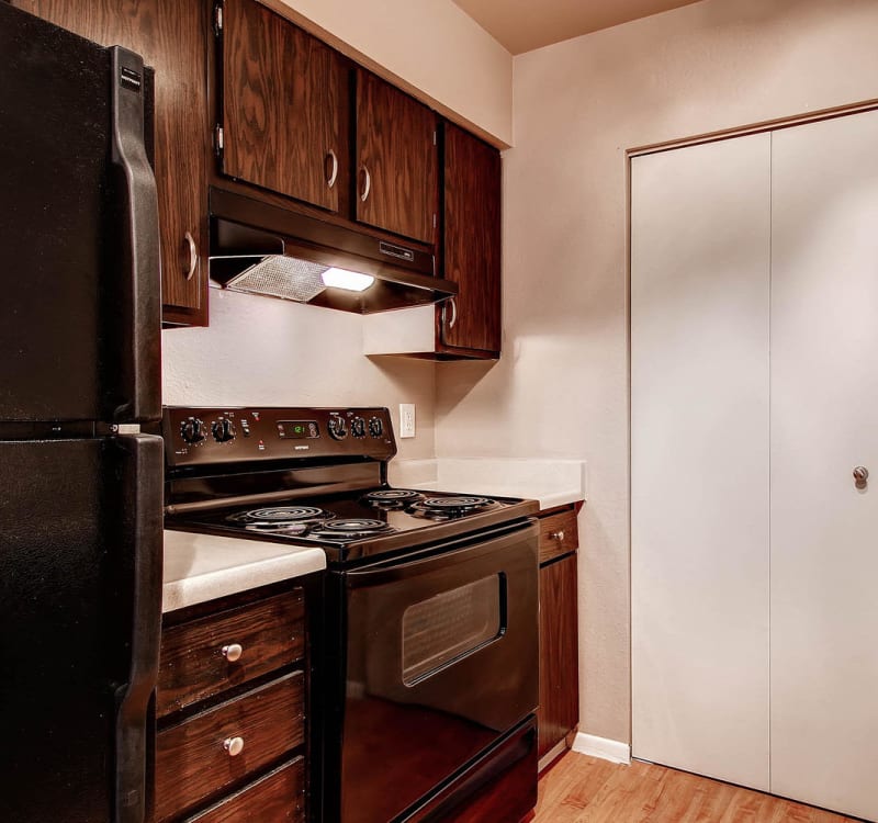 Kitchen with black appliances at Arvada Village Apartment Homes in Arvada, Colorado