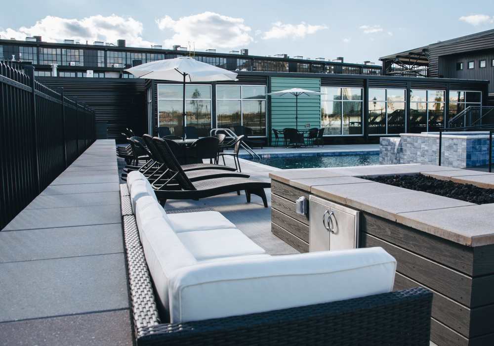 Rooftop lounge area with white sofa seating and pool view at City View Lofts in Richmond, Virginia