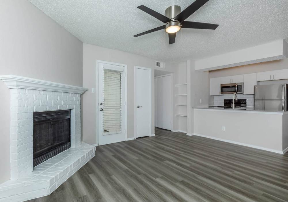 Living room with plank flooring and a fireplace at Tides on Randol West in Fort Worth, Texas