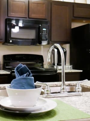 Gourmet kitchen with granite countertops and dark wood style cabinetry at Anatole on MacArthur in Oklahoma City, Oklahoma