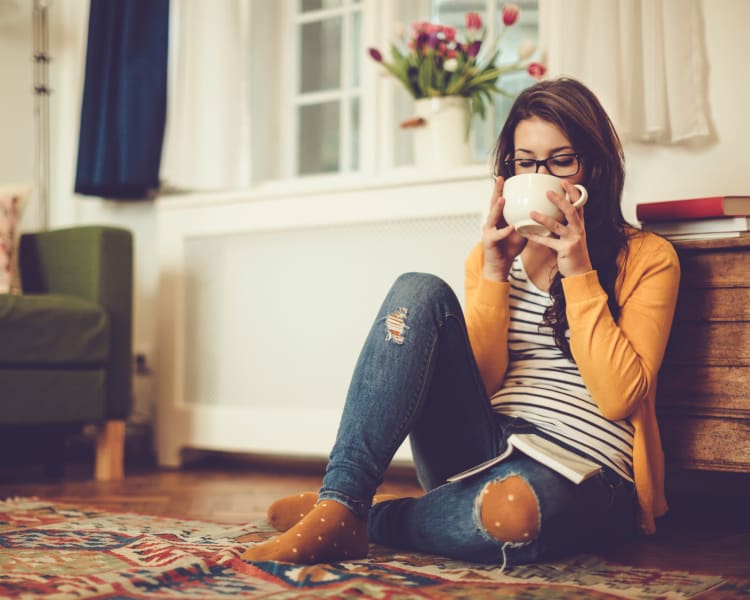 Resident relaxing with a cup of tea in her new home at Sofi Westview in San Diego, California