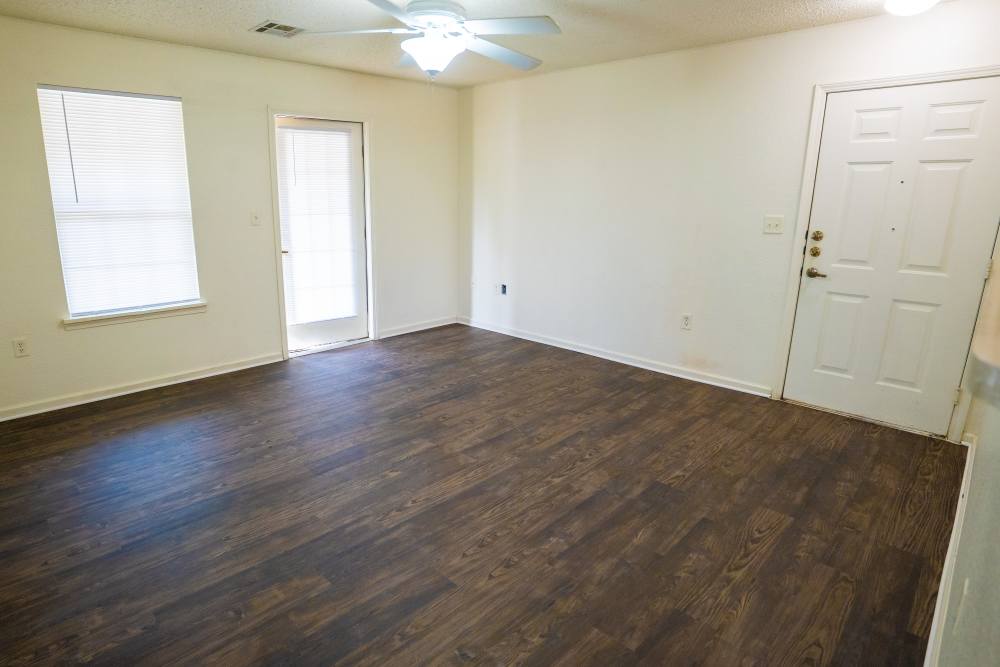 Living room with ceiling fan and wood-style flooring at Jacksonville Pines in Jacksonville, Texas