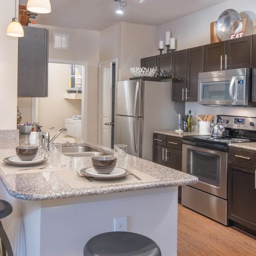 Granite countertops and shaker-style cabinetry in a model home's kitchen at Carrington Oaks in Buda, Texas