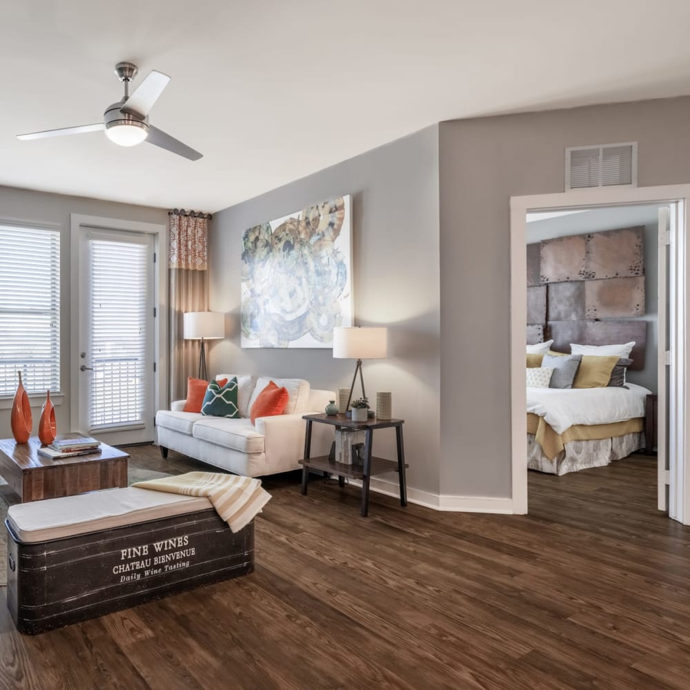 Wood flooring in an apartment living room and a view of the main bedroom at Liberty Mill in Germantown, Maryland