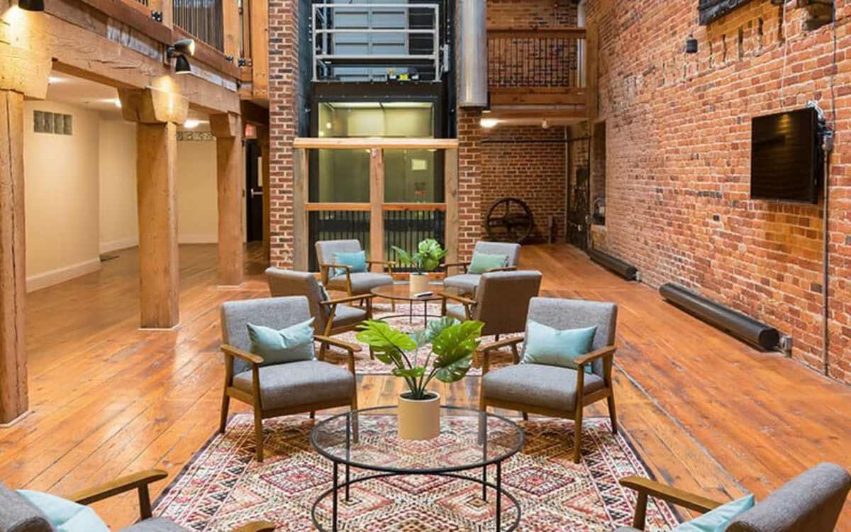 Lounge area with wall-mounted TV in the clubhouse at High Street Lofts in Petersburg, Virginia