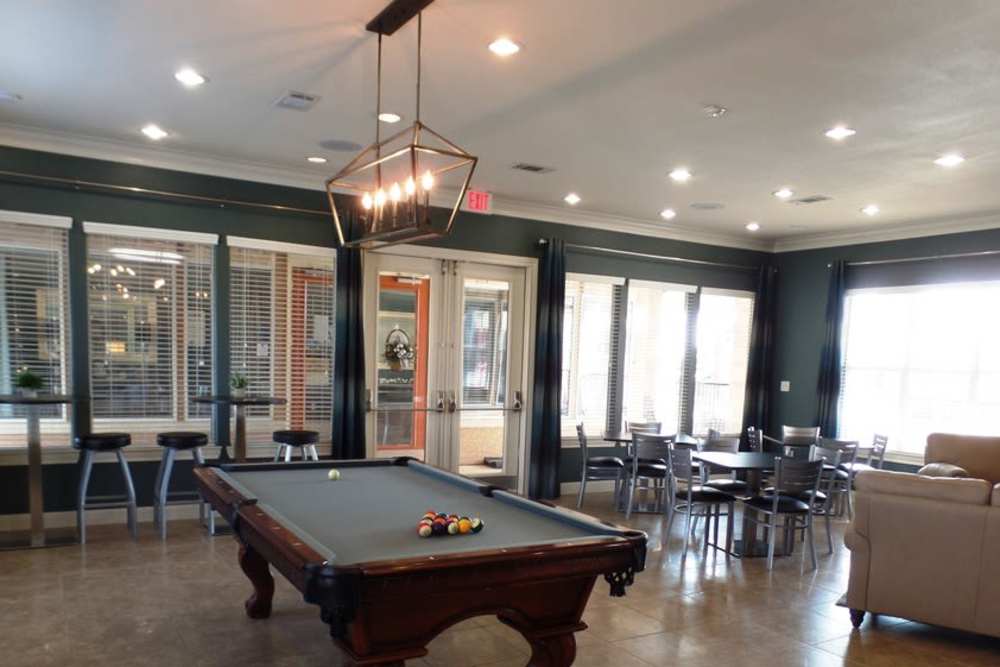Upscale and large resident clubhouse with couches, tables, pool table at The Abbey at Stone Oak in San Antonio, Texas