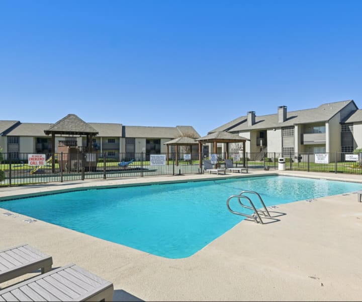 Swimming pool with lounge chairs at Courts of Bedford in Bedford, Texas