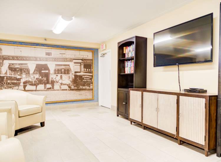 Community lounge with couches and a TV at Borden Place Apartments in Fall River, Massachusetts