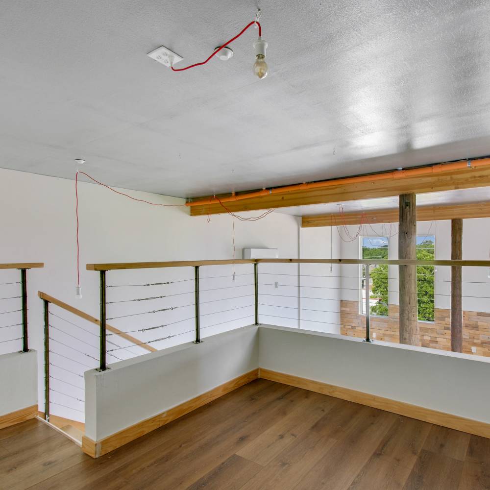 Loft area with wood-style flooring at The Lofts at 305 in Bryan, Texas