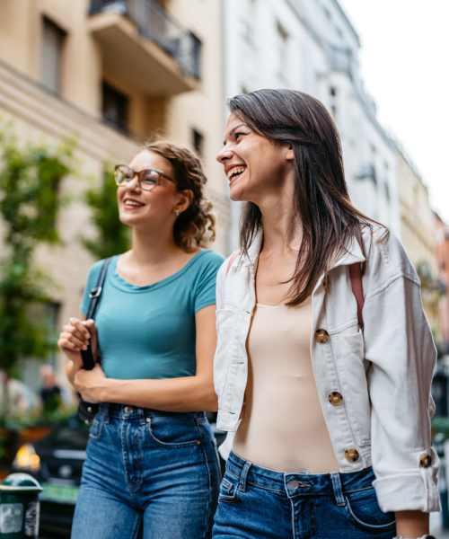 Two women smiling while walking down a street at Latitude at South Portland in Portland, Maine