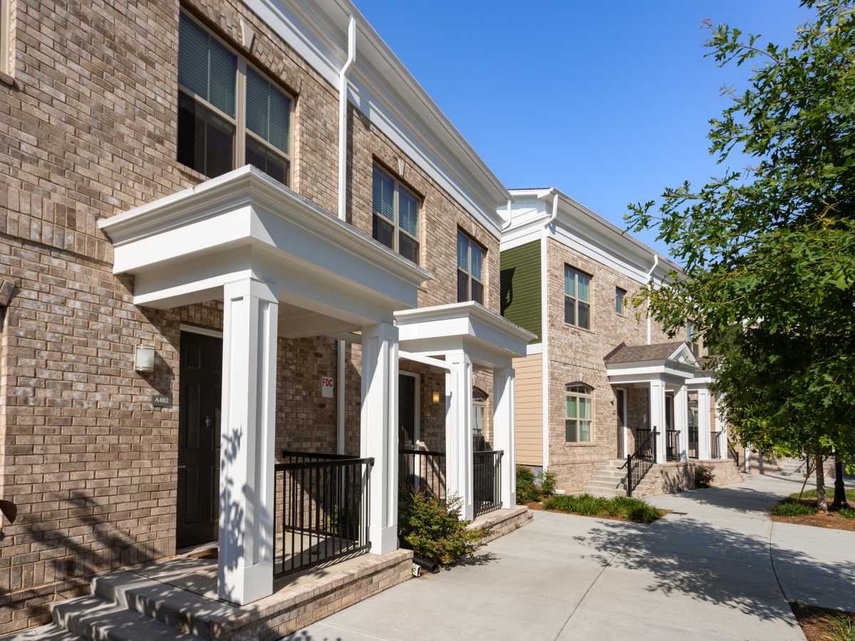 Gated brick exterior with white columns and steps at Ardmore & Twenty Eighth in Atlanta, Georgia