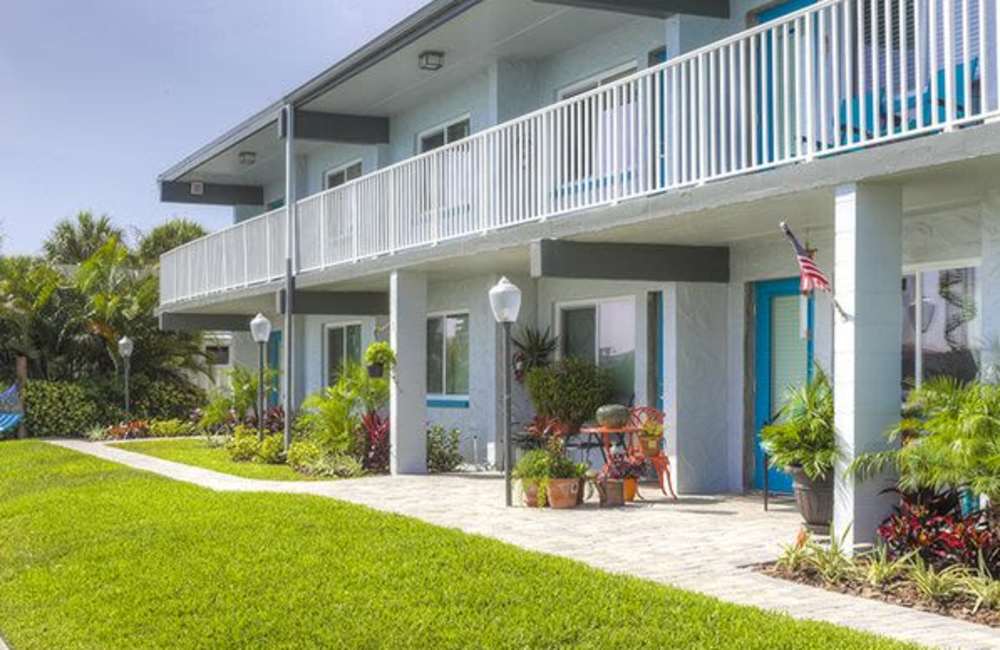 Property exterior with a spacious lawn at Bayside Villas Apartment Homes in South Pasadena,Florida