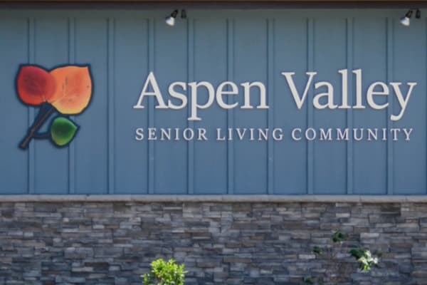 Logo and signage on a wall outside Aspen Valley Senior Living in Boise, Idaho
