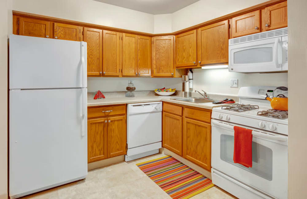 Fully equipped kitchen with white appliances at Blackhawk Apartment Homes in Elgin, Illinois